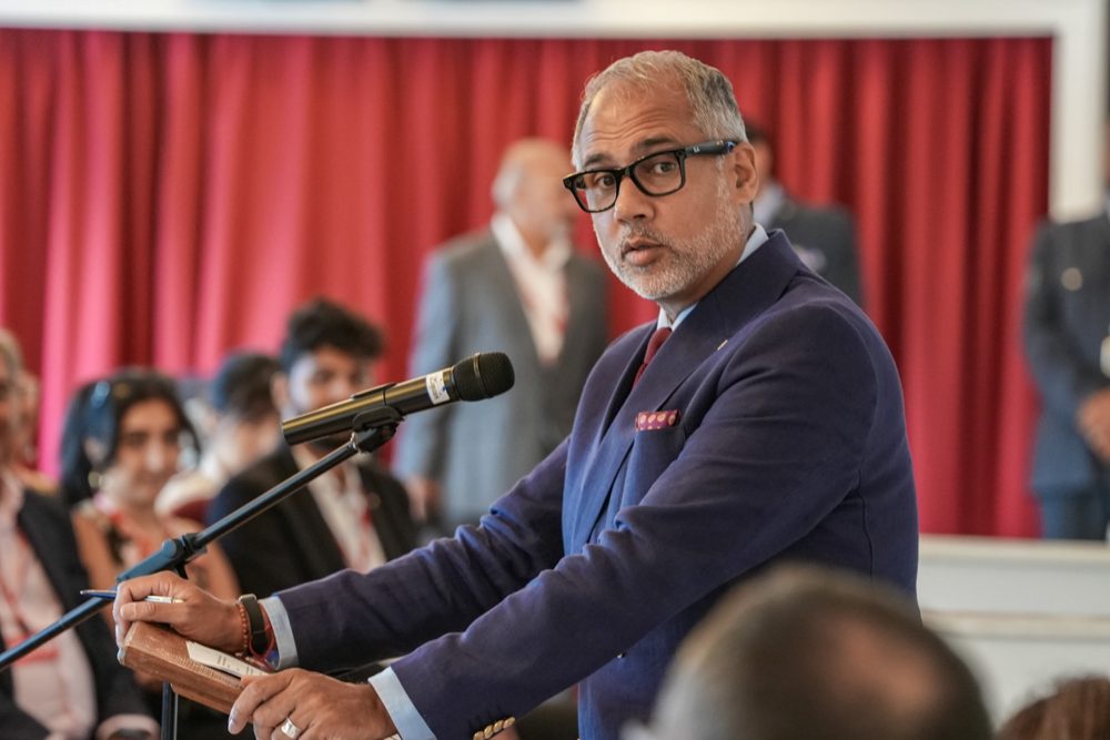 Alpesh Patel OBE speaking at a lectern